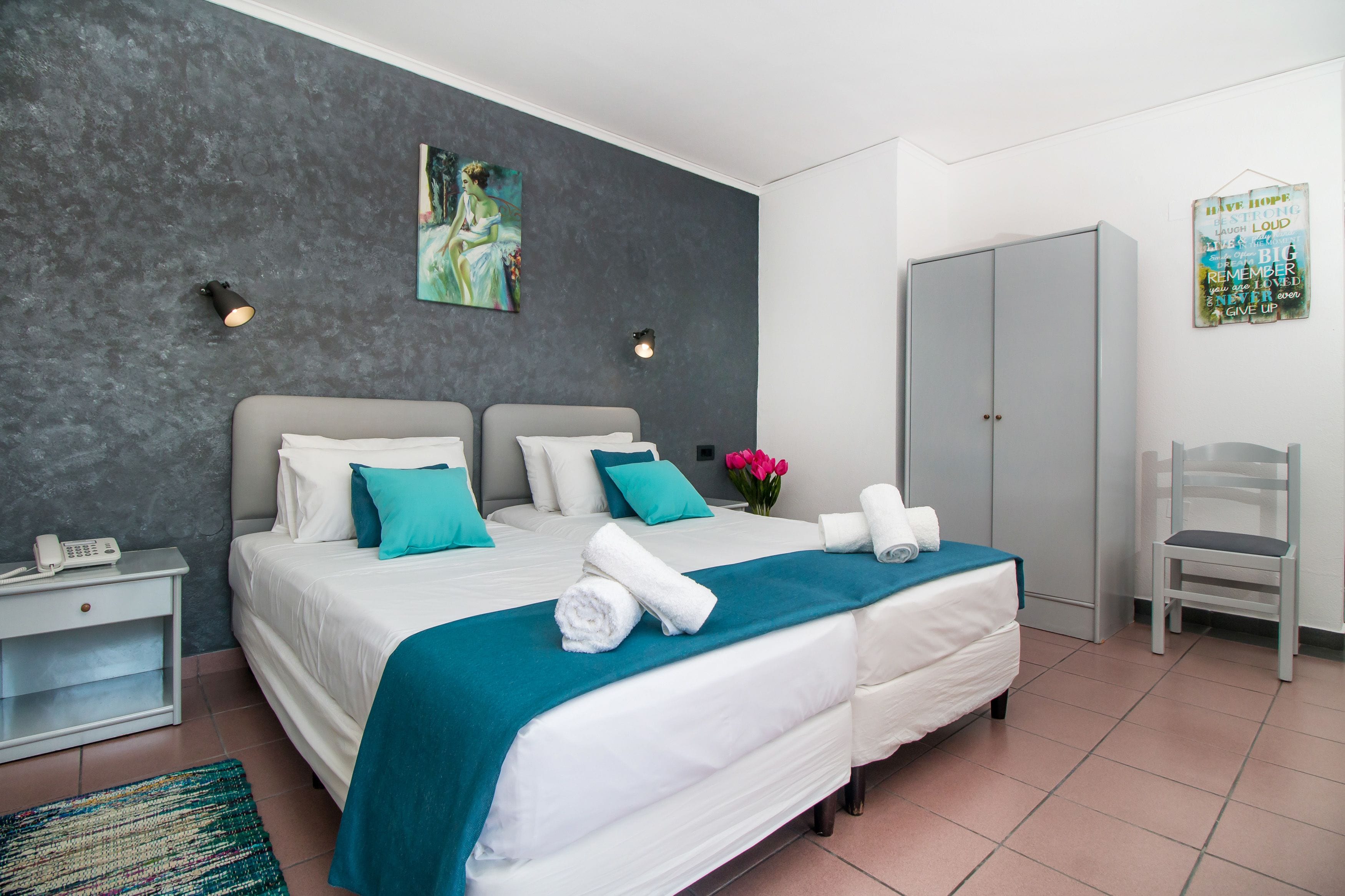 Une chambre moderne avec un grand lit, deux tables de chevet, une armoire et une chaise.