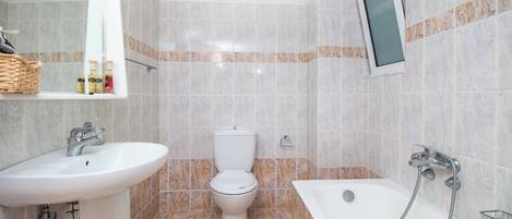 A bathroom with a sink, toilet, and bathtub.