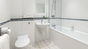 Un baño moderno con inodoro, lavamanos y bañera.