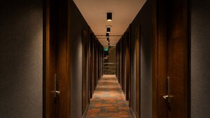 A long, narrow hallway with wooden doors on both sides, a patterned carpet, and a ceiling light fixture. - The Biancho Hotel Pera (Istanbul)