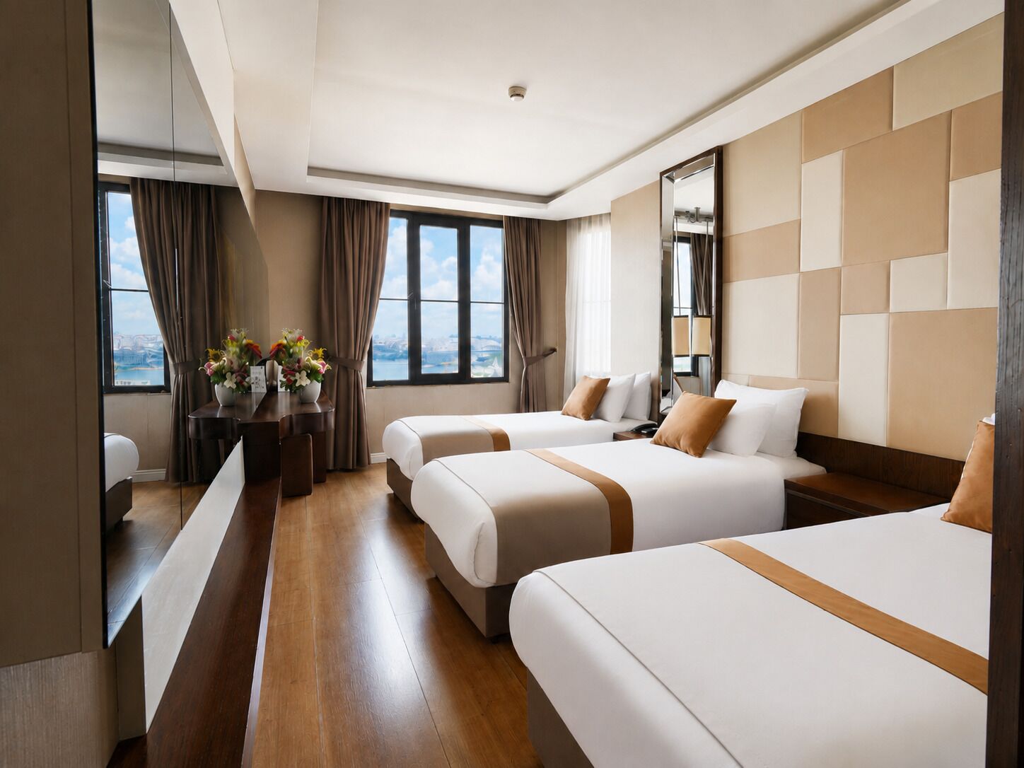 Habitación de hotel con dos camas, un escritorio y vistas a la ciudad.