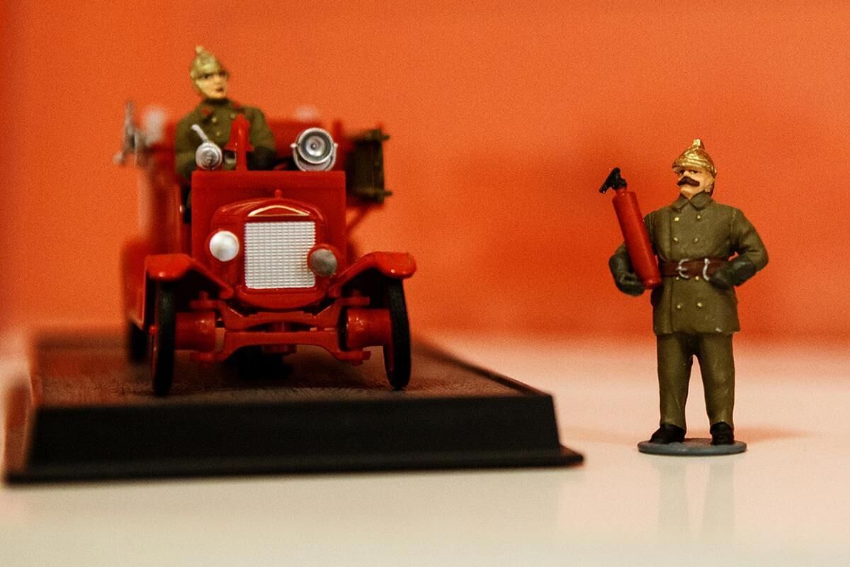 Une maquette d’un camion de pompiers d’époque, accompagnée d’une figurine de soldat tenant une bombe.