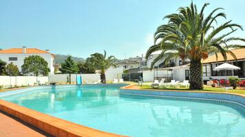 Alberca al aire libre y camastros