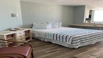 Un dormitorio con cama, escritorio, silla, cómoda y espejo.