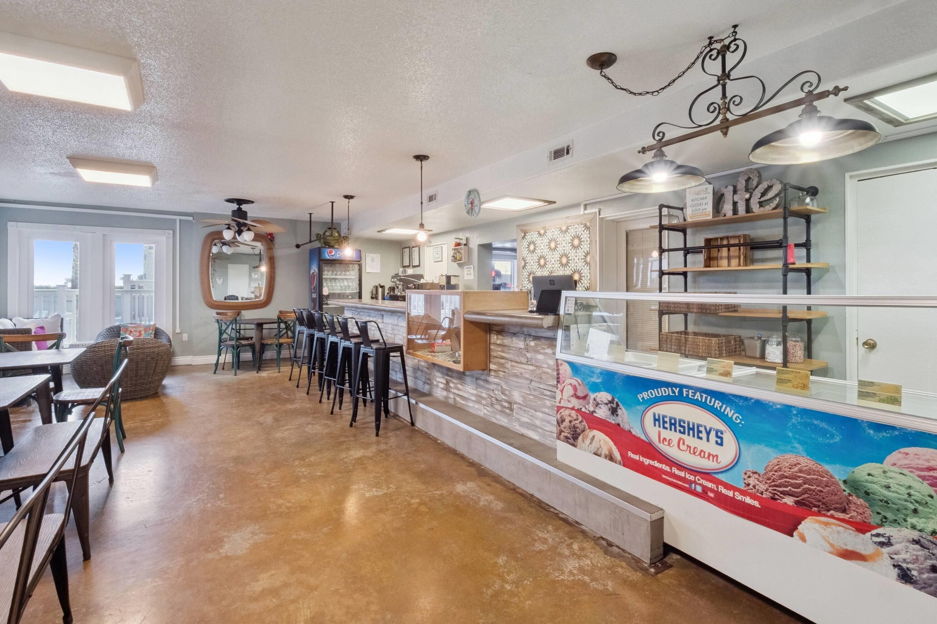 Un restaurant avec un comptoir, des chaises et un présentoir de glaces Hershey's.