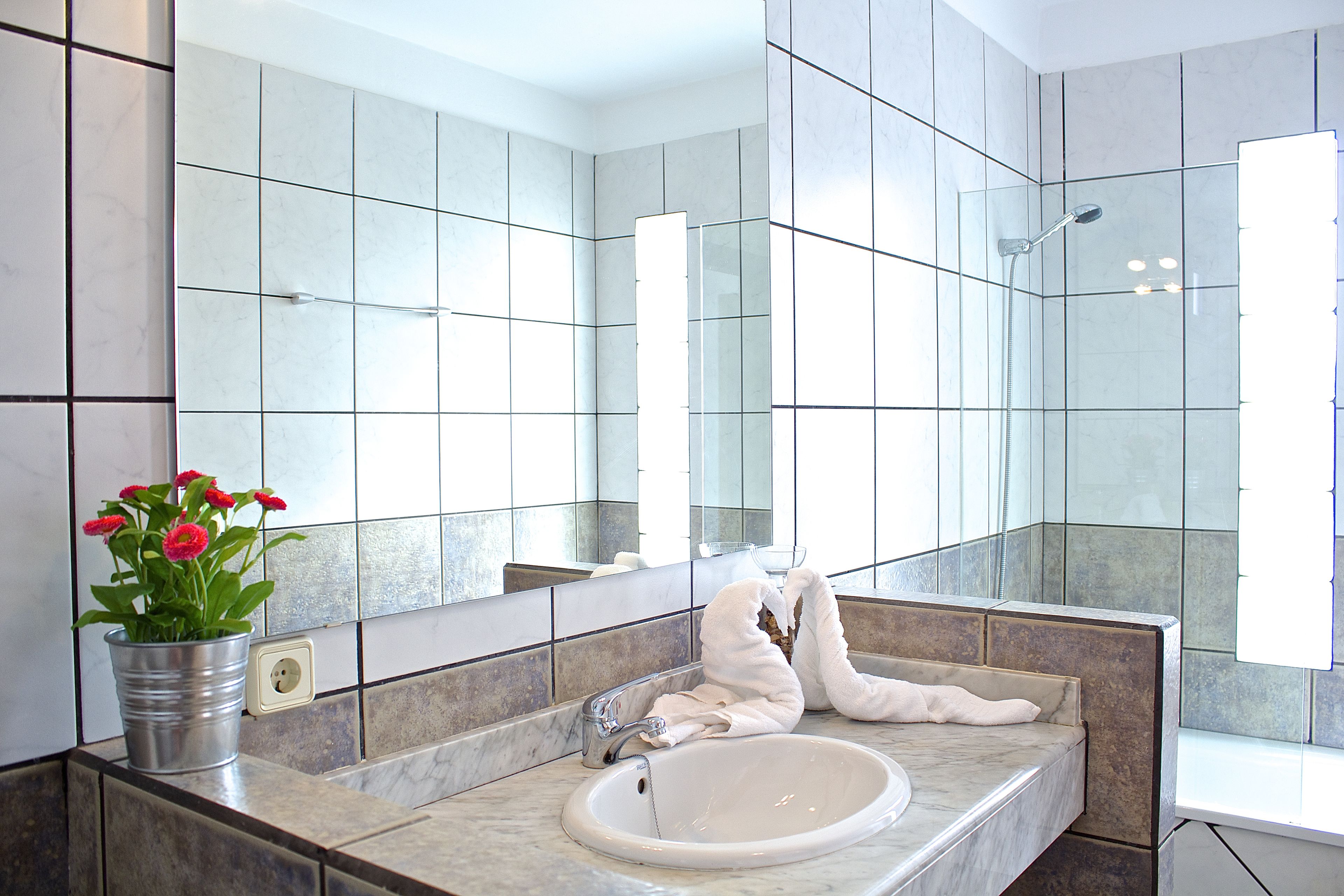 Un bagno con uno specchio grande, un lavandino e una doccia.
