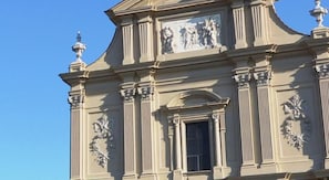 A classical building facade with ornate columns and a central window. - Alex Home (Florence)
