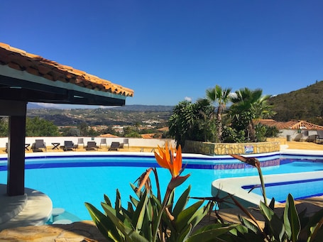 Una piscina al aire libre, sillones reclinables de piscina