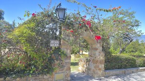 A stone archway with a sign reading "MINI GOLF" and a street lamp above it.