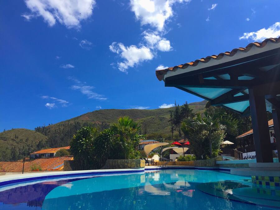 Una piscina al aire libre, sillones reclinables de piscina