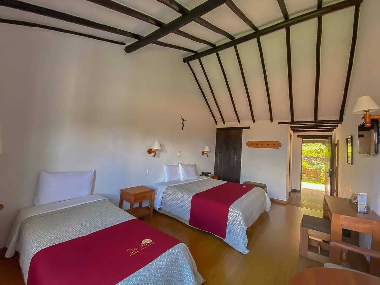 Una habitación con dos camas, muebles de madera y vistas al exterior.