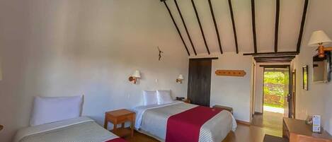 Una habitación con dos camas, muebles de madera y vistas al exterior.