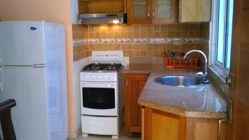 Full-sized fridge, stovetop, cookware/dishes/utensils