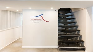 A modern staircase with a logo for 'Lucky House' in Bangkok.