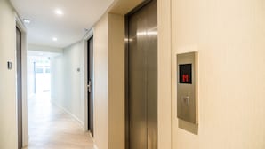 A hallway with an elevator and a digital display showing the number 11.