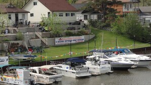 A waterfront property with a dock, boats, and a sign for Edgewater Cottages. - Edgewater Resorts - Edgewater Cottages (Wasaga Beach)