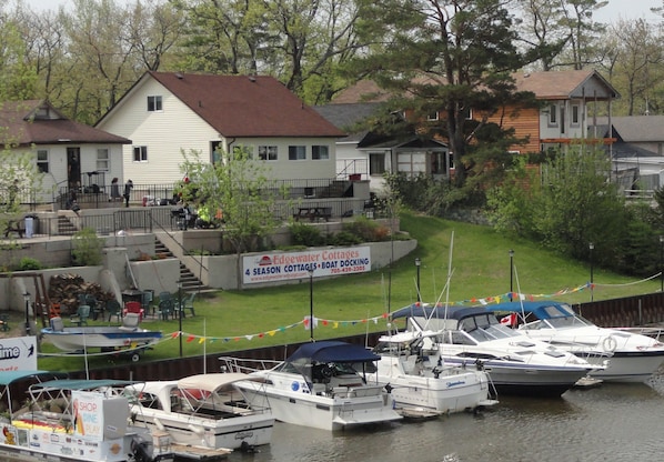 A waterfront property with a dock, boats, and a sign for Edgewater Cottages.