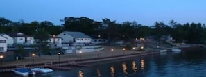 A waterfront property with a dock, boats, and houses along the shore.