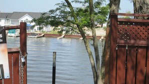 A wooden dock with a chain and padlock, a boat, and a house in the background. - Edgewater Resorts - Edgewater Cottages (Wasaga Beach)