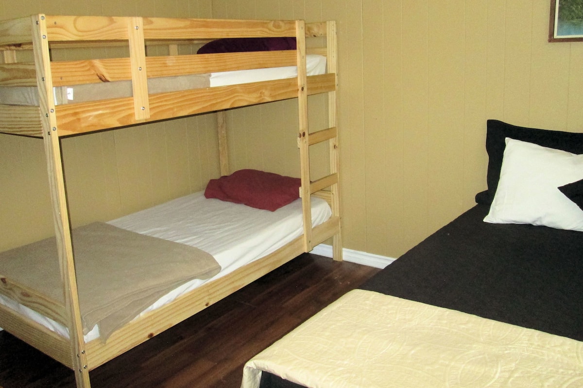 A bunk bed with a lower bunk and a mattress on the floor.