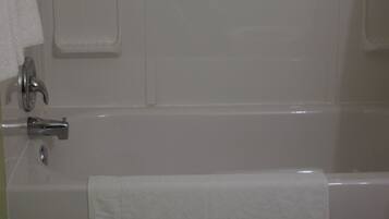 A bathroom with a bathtub, a toilet, and a towel rack.