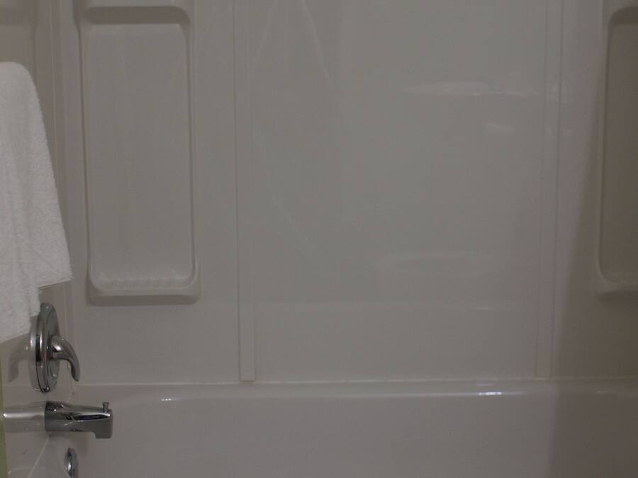 A bathroom with a bathtub, a toilet, and a towel rack.
