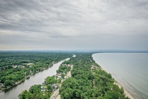 An aerial view of a river flowing through a densely wooded area with residential properties along the banks. - Edgewater Resorts - Edgewater Inn (Wasaga Beach)