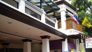 A building with a covered entrance, columns, and a signboard. - Rambuttri House (Bangkok)