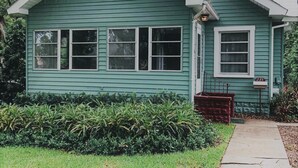 Une petite maison de plain-pied, dotée d’un toit à pignon et d’un porche à l’avant.