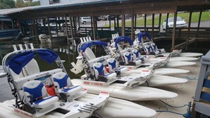 Une rangée de petits bateaux à moteur était amarrée dans une marina, sous une zone abritée par un auvent.