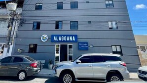 A modern building with a sign reading "ALAGOANA" and a contact number. - Hotel Pousada Alagoana (Maceió)