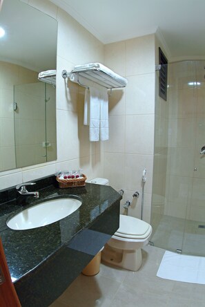 A bathroom with a sink, toilet, and glass-enclosed shower.