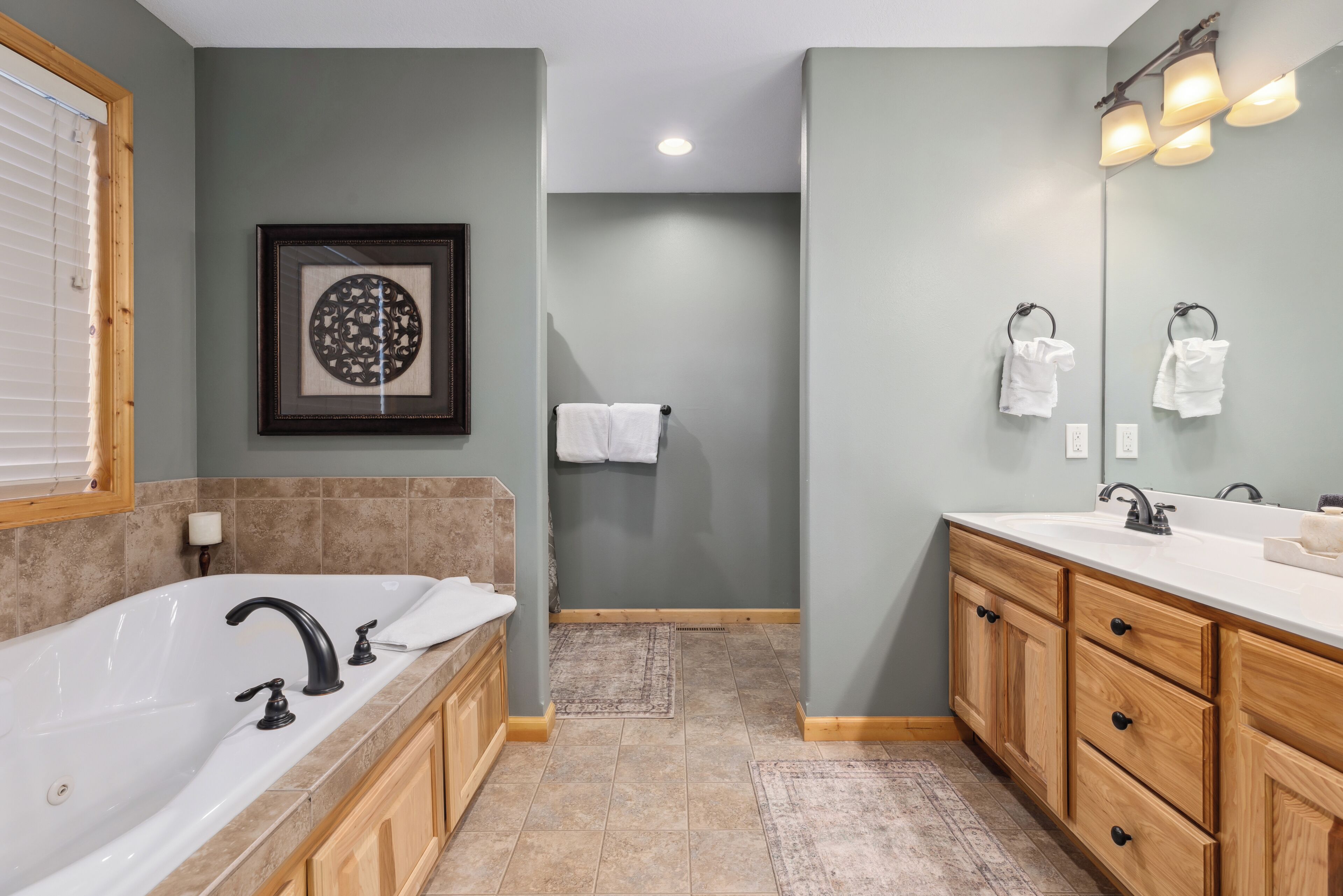 A modern bathroom with a freestanding bathtub, wooden vanity, and a large mirror.