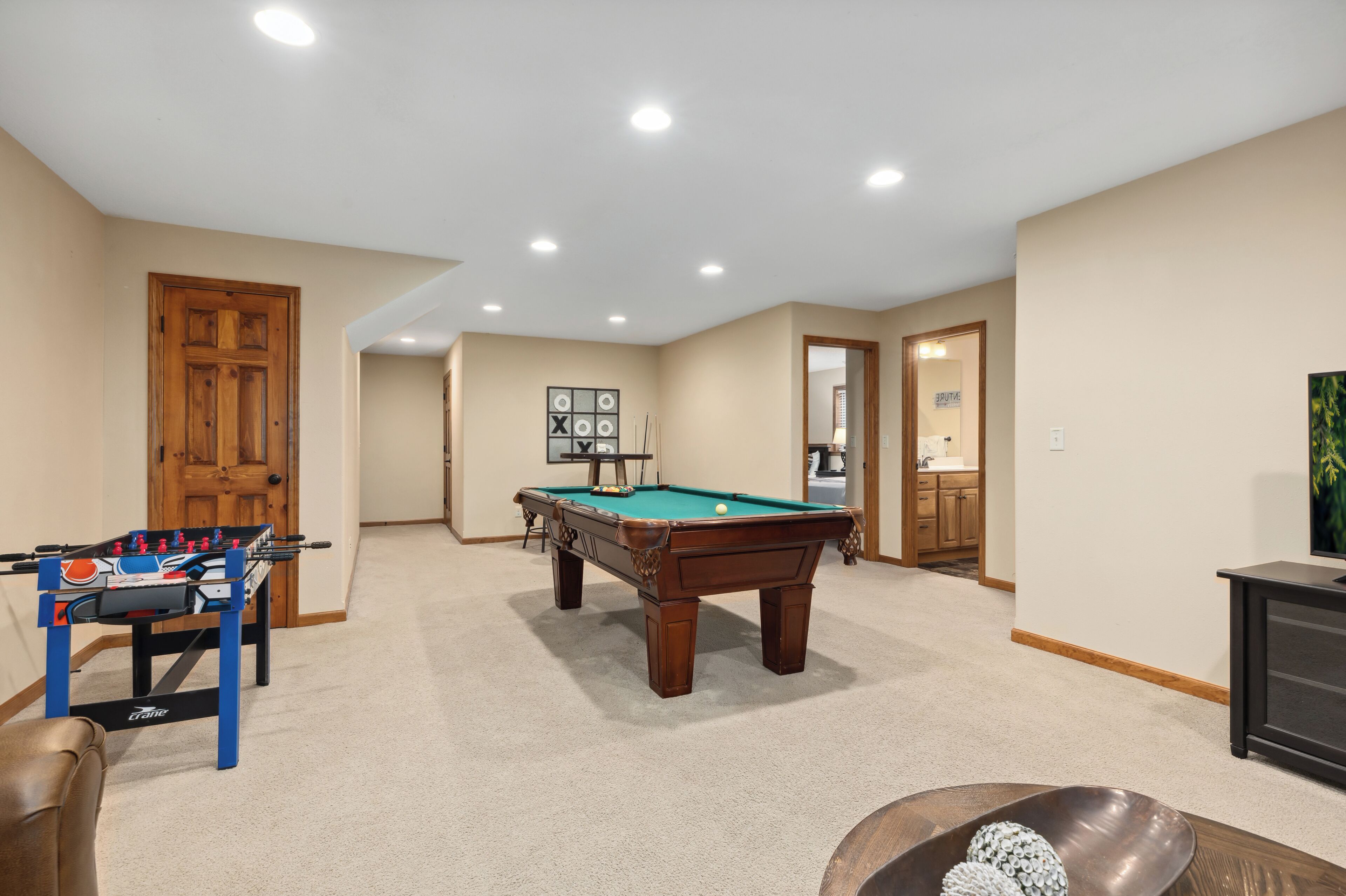 Une pièce équipée d’une table de billard, d’un baby-foot et d’un téléviseur.