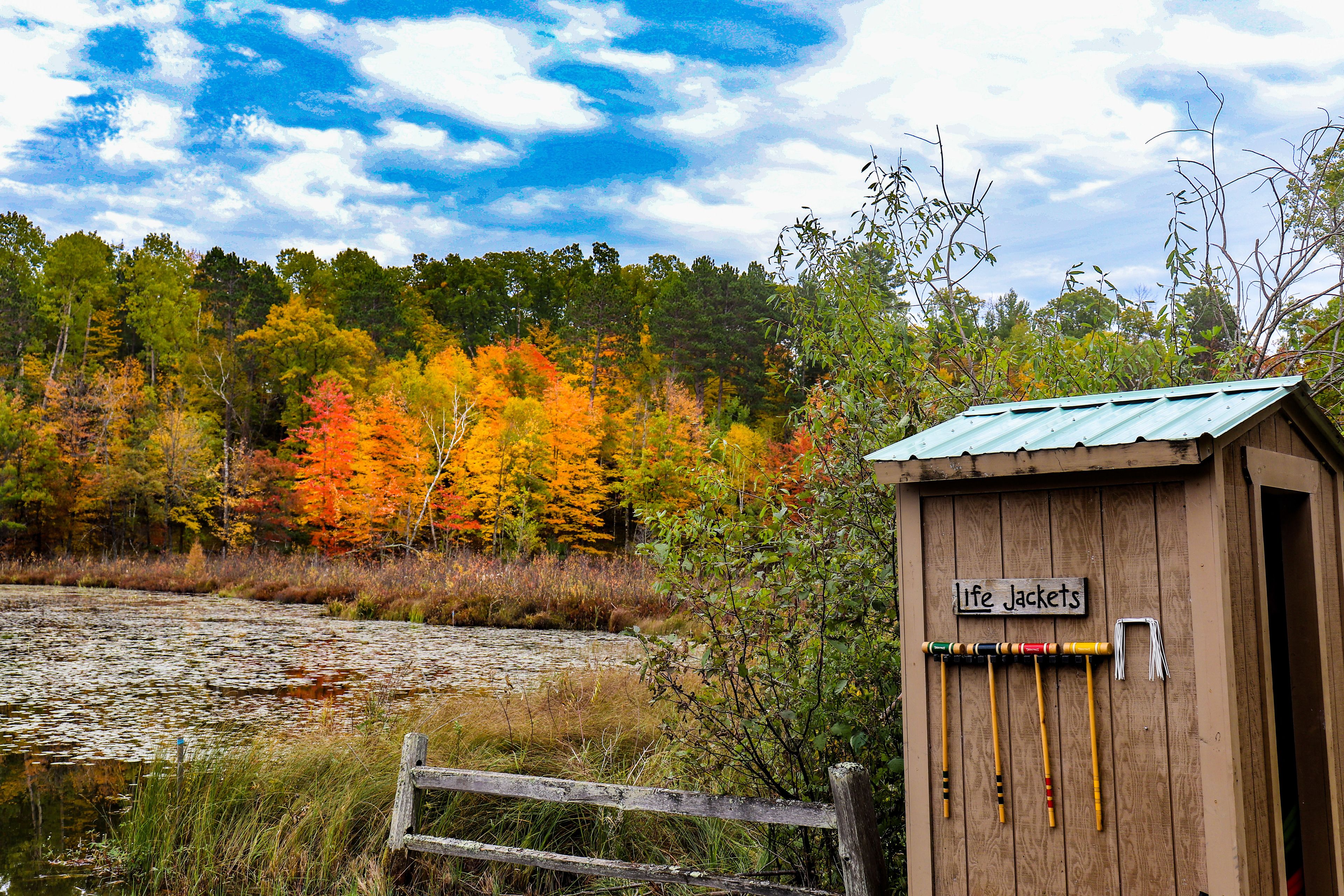 A wooden cabin with a sign reading "Life Jackets" and a wooden fence in front.