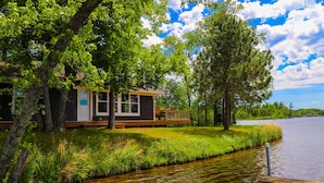 Un chalet au bord du lac, doté d’une terrasse et d’un quai.