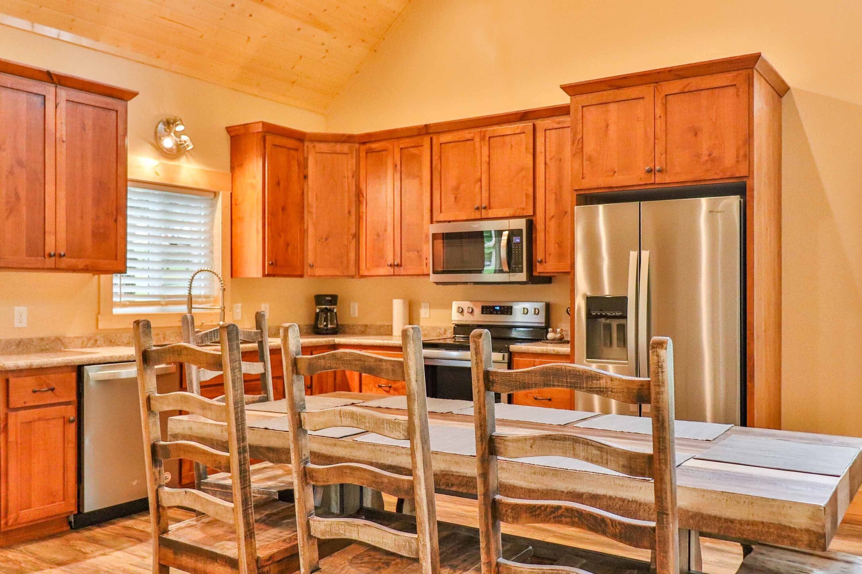 A kitchen with wooden cabinets, a stainless steel refrigerator, a microwave, and a dining table with chairs.