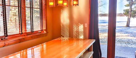A wooden table in a room with a large window and a view of a snowy landscape.