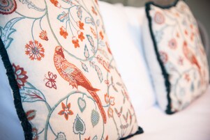 Primer plano de dos almohadas con un estampado floral y de pájaros.