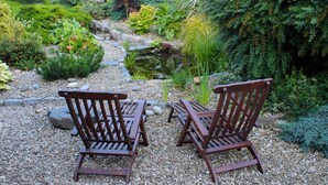 A garden with a gravel path, two wooden chairs, and a small pond. - Blackwell House (Craigavon)