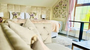 A bedroom with a bed, a sofa, a radiator, a window with curtains, and a wall with floral wallpaper. - Blackwell House (Craigavon)