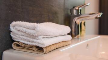 A stack of folded towels on a bathroom sink.