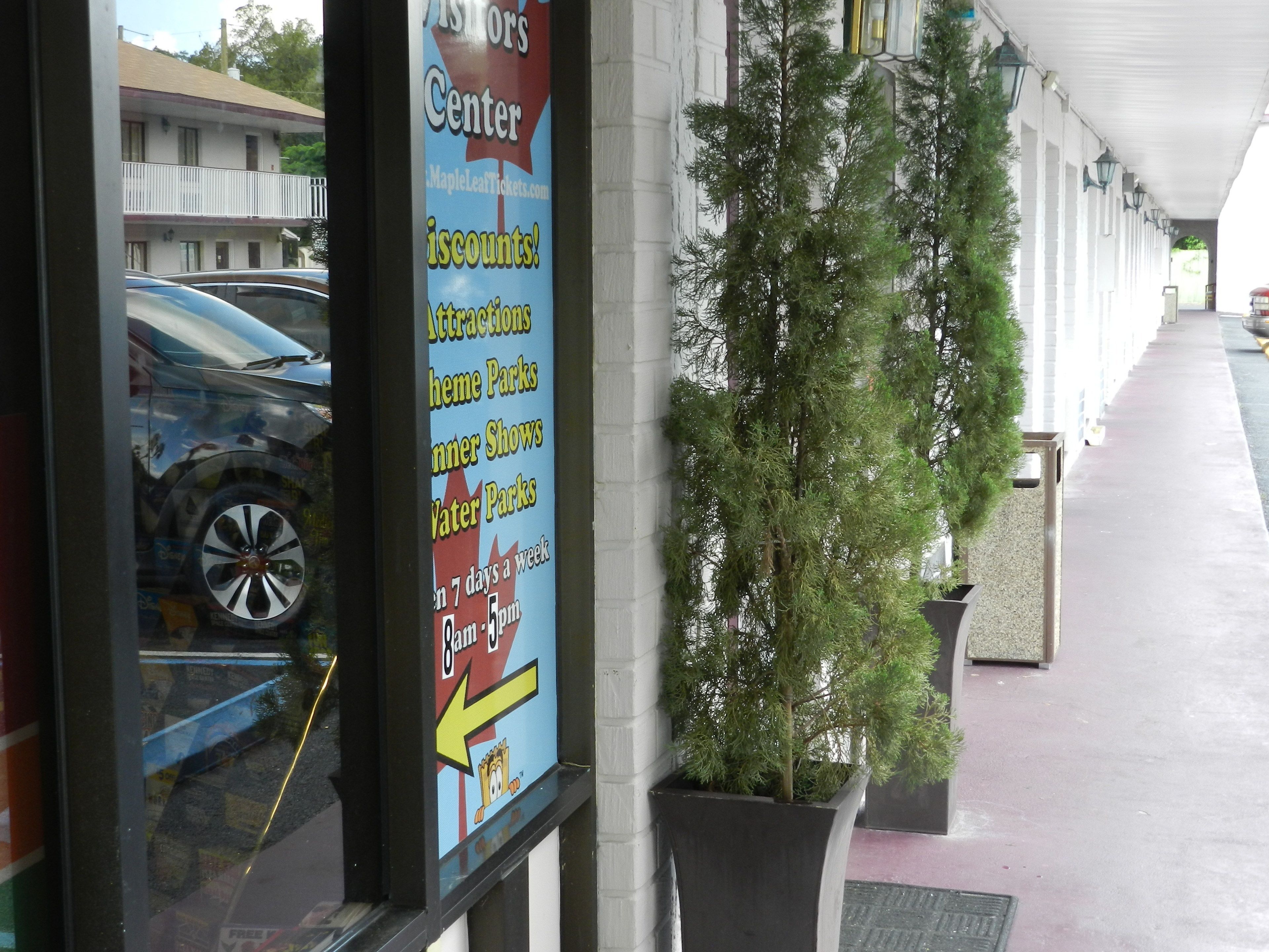 A storefront with a sign advertising attractions and shows, including theme parks and concerts, available 7 days a week from 8am to 5pm.