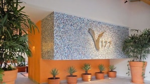 Una zona de recepción con un muro de mosaico y varias plantas en macetas.