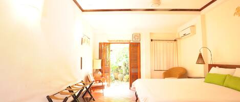 Una habitación de hotel con cama, una silla, una lámpara y una ventana.