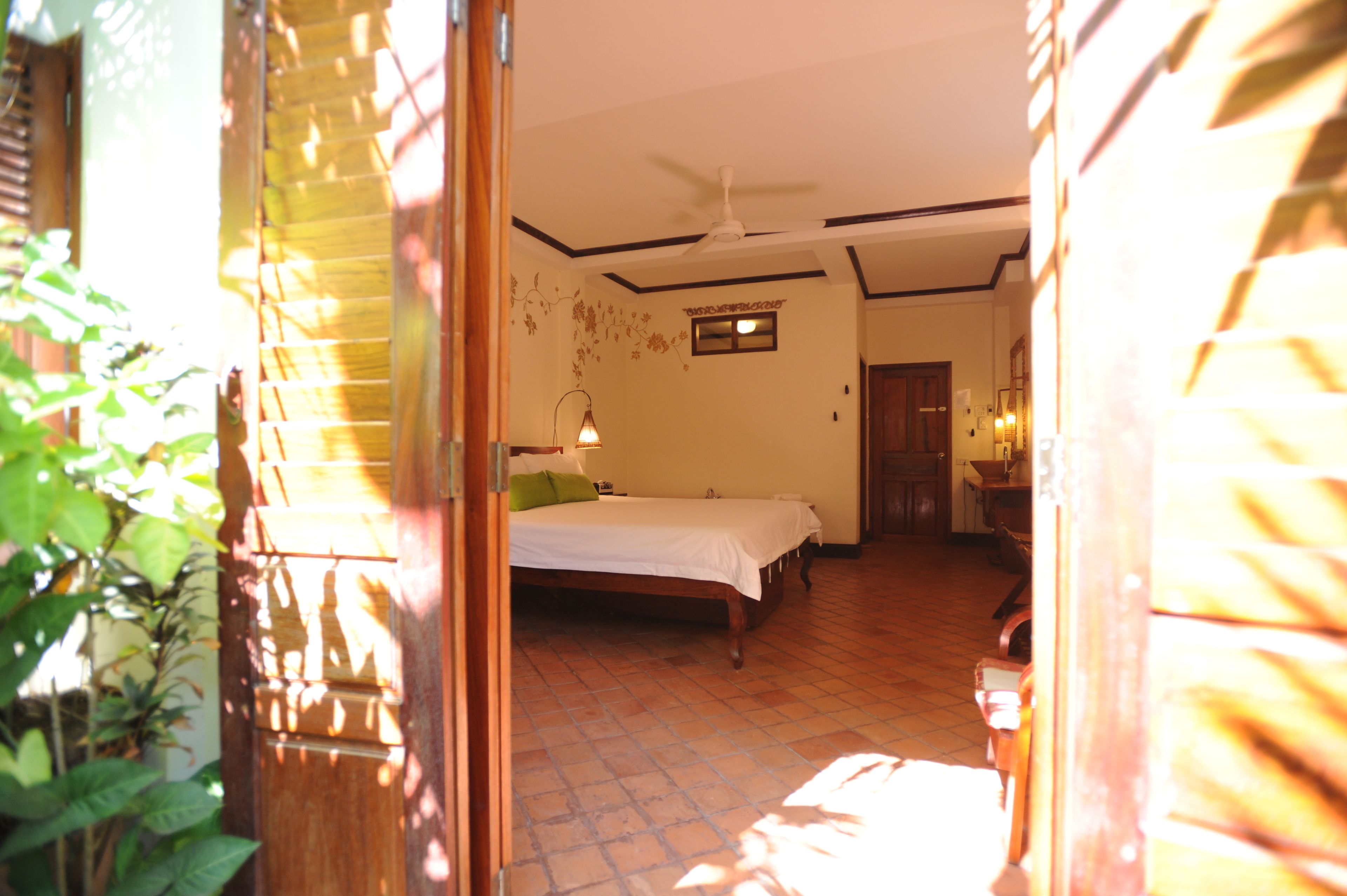 A bedroom with a bed, a ceiling fan, and a window.