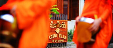 A wooden sign with text and a lotus symbol, indicating a location named "Lotus Villa."