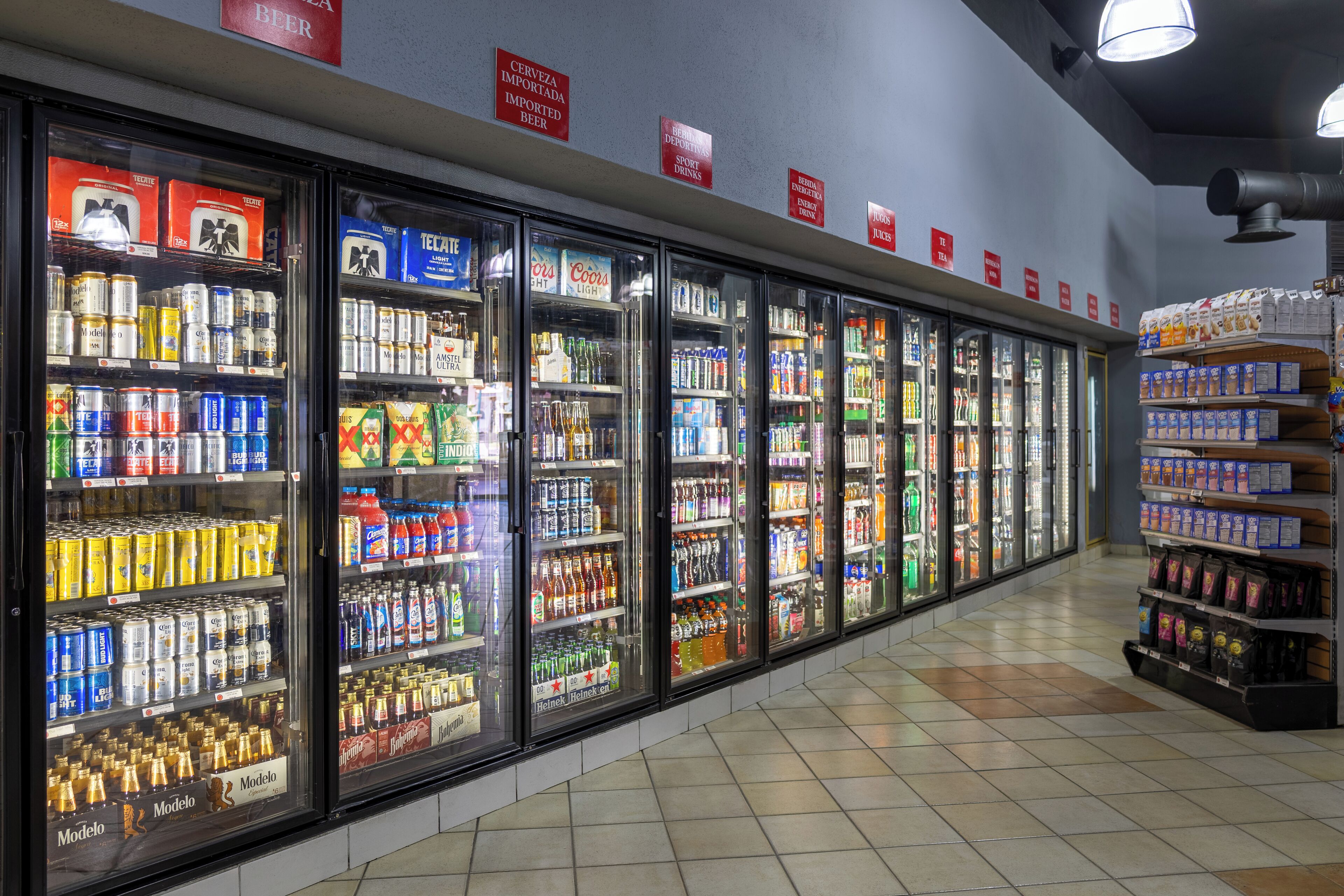 A refrigerated display case in a store with various beverages and snacks.