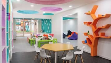 A children's play area with colorful furniture, a table, and bean bags.