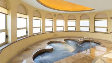 A spa area with a hot tub, arched windows, and a curved ceiling.